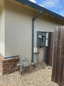 A house with an electrical panel and water meter.